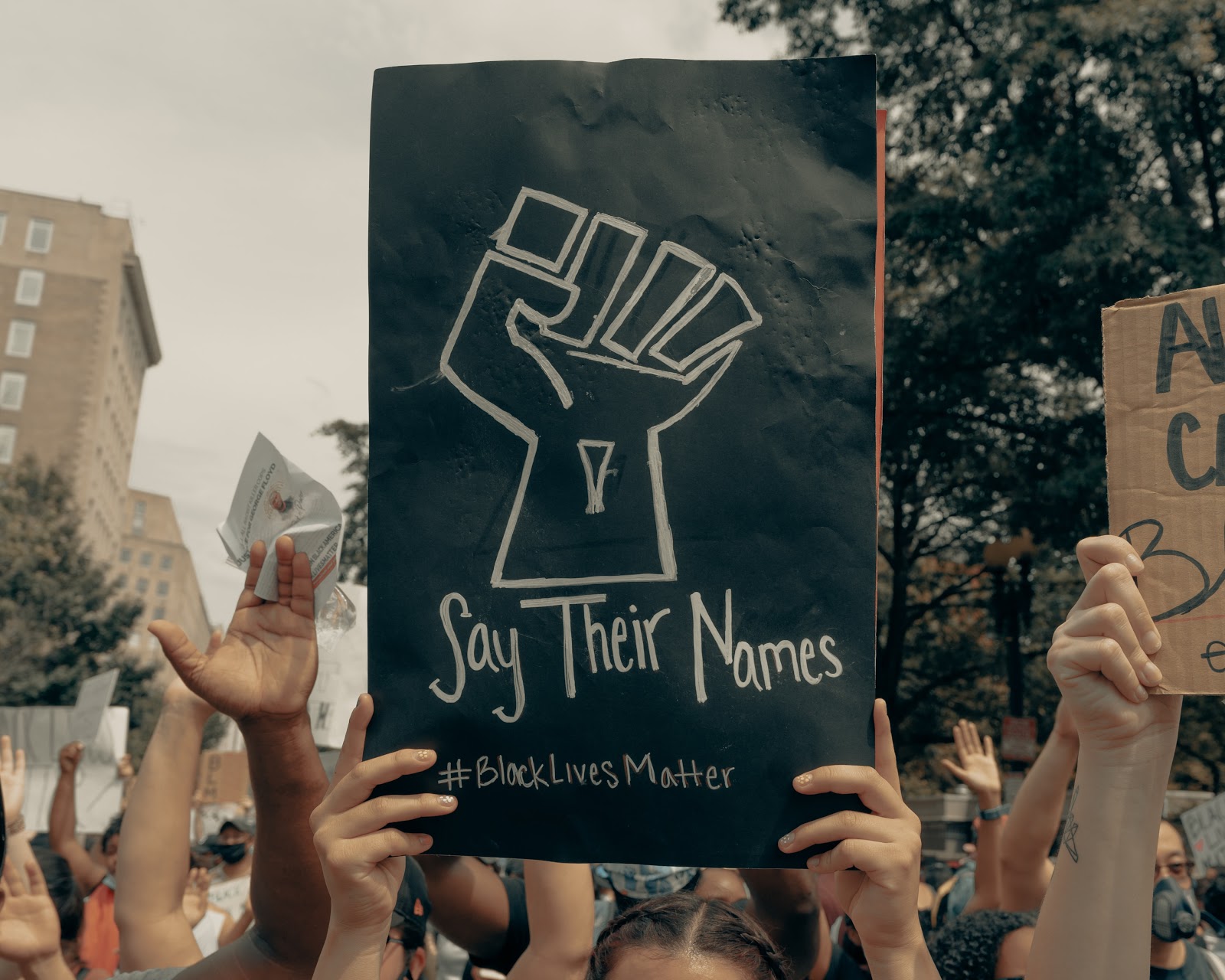 A sign reads "say their name" at a Black Lives Matter rally