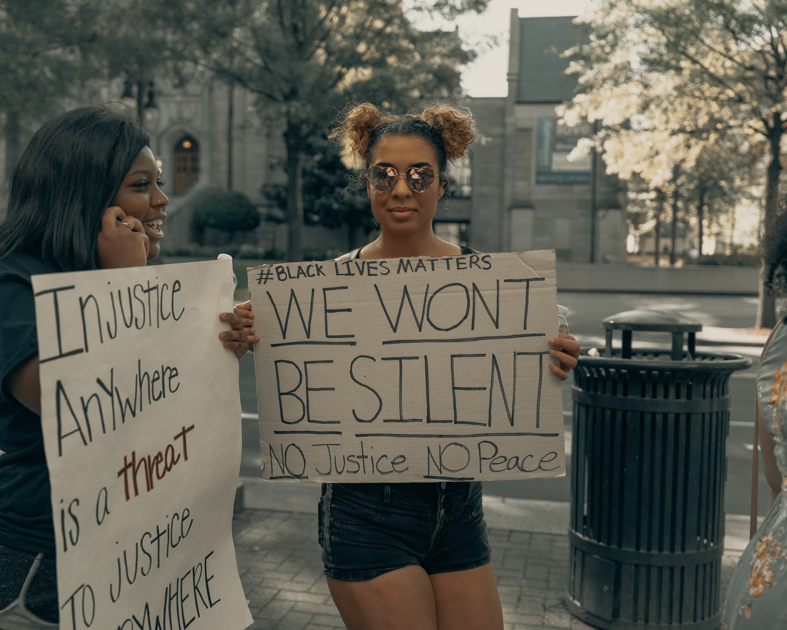 A woman holds a sign that reads "we won't be silent" in preparation for a Black Lives Matter protest